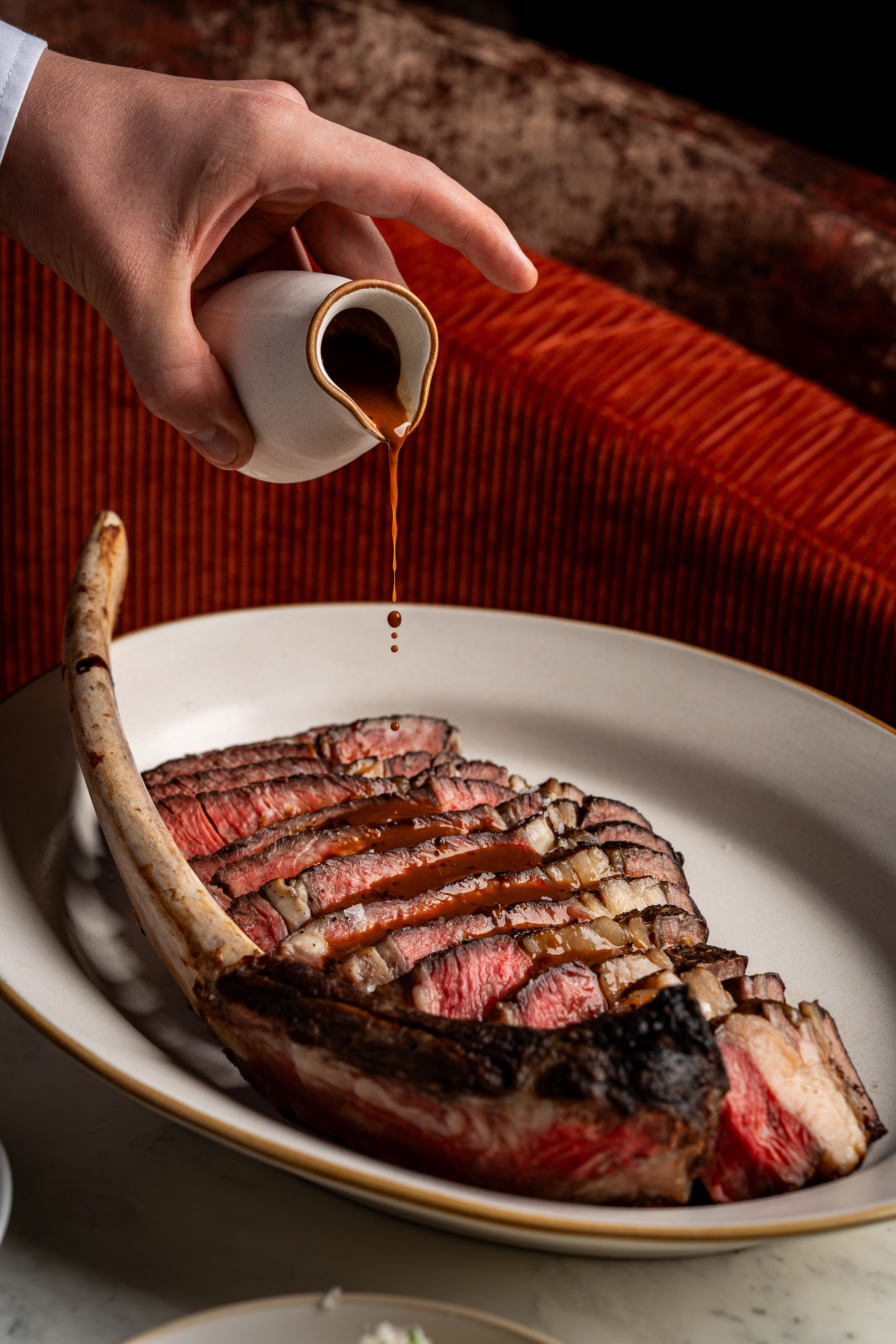 Sauce being poured on a steak