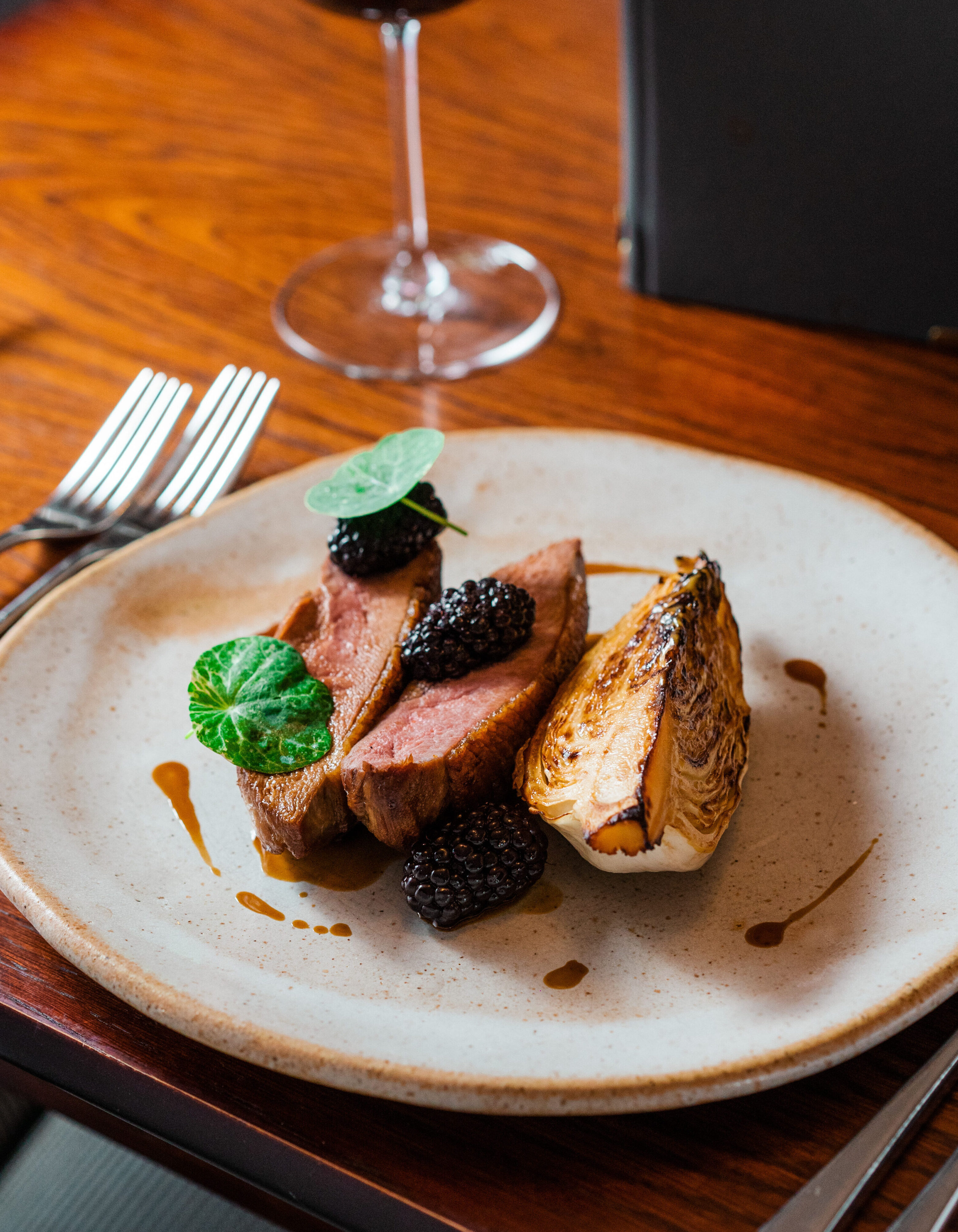 Cooked Duck on a white plate with roasted vegtables